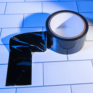 Roll of black bondage tape on a white tiled surface Nudie Co
