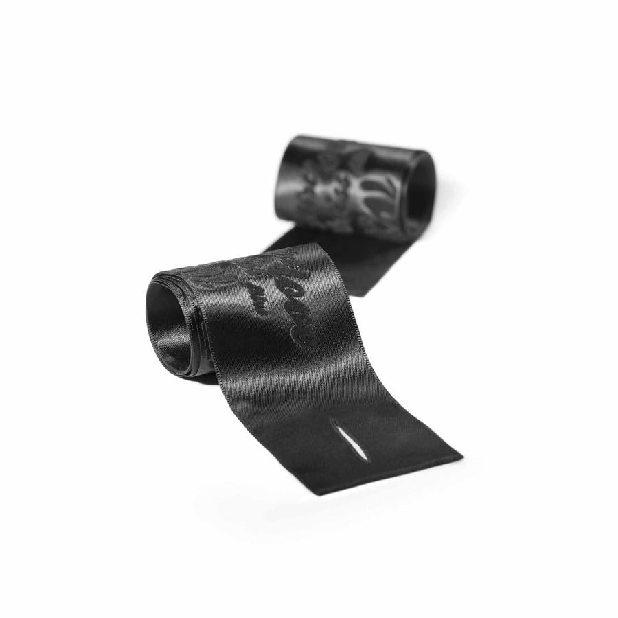 Pair of rolled black satin handcuffs for roleplay and sensual pleasure Nudie Co