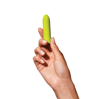 Hand holding a lime green bullet vibrator by Dame Nudie Co