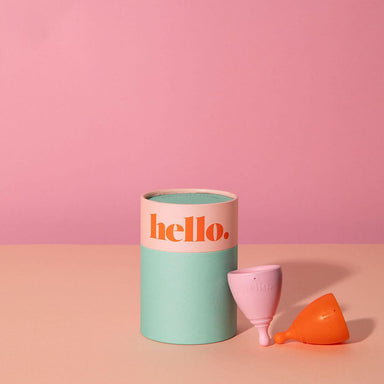 Green and pink cylinder box with two pink and orange period cups Nudie Co