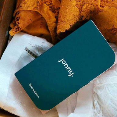 Pack of 13 vegan condoms on a bed Nudie Co