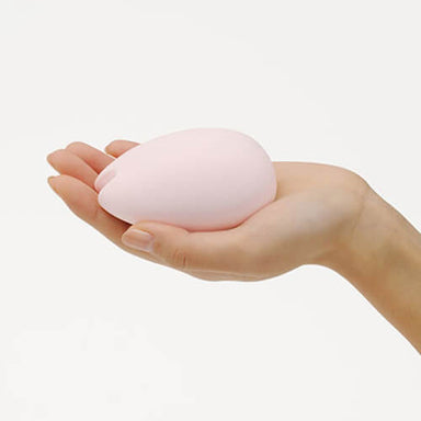 Woman's hand holding a pink Sakura clitoral vibrator by Tenga Iroha Nudie Co