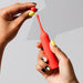 Hands holding a red clitoral vibrator and a detachable round silicone head  Nudie Co