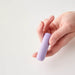 Woman's hand holding a Gaia eco-friendly biodegradable and rechargeable purple bullet vibrator Nudie Co