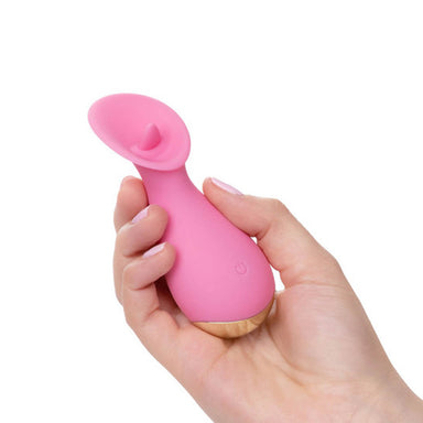 Woman's hand holding a pink clitoral vibrator with a flickering tip Nudie Co