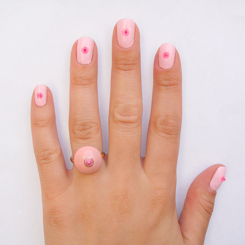 Woman's hand with pink boob ring on ring finger Nudie Co