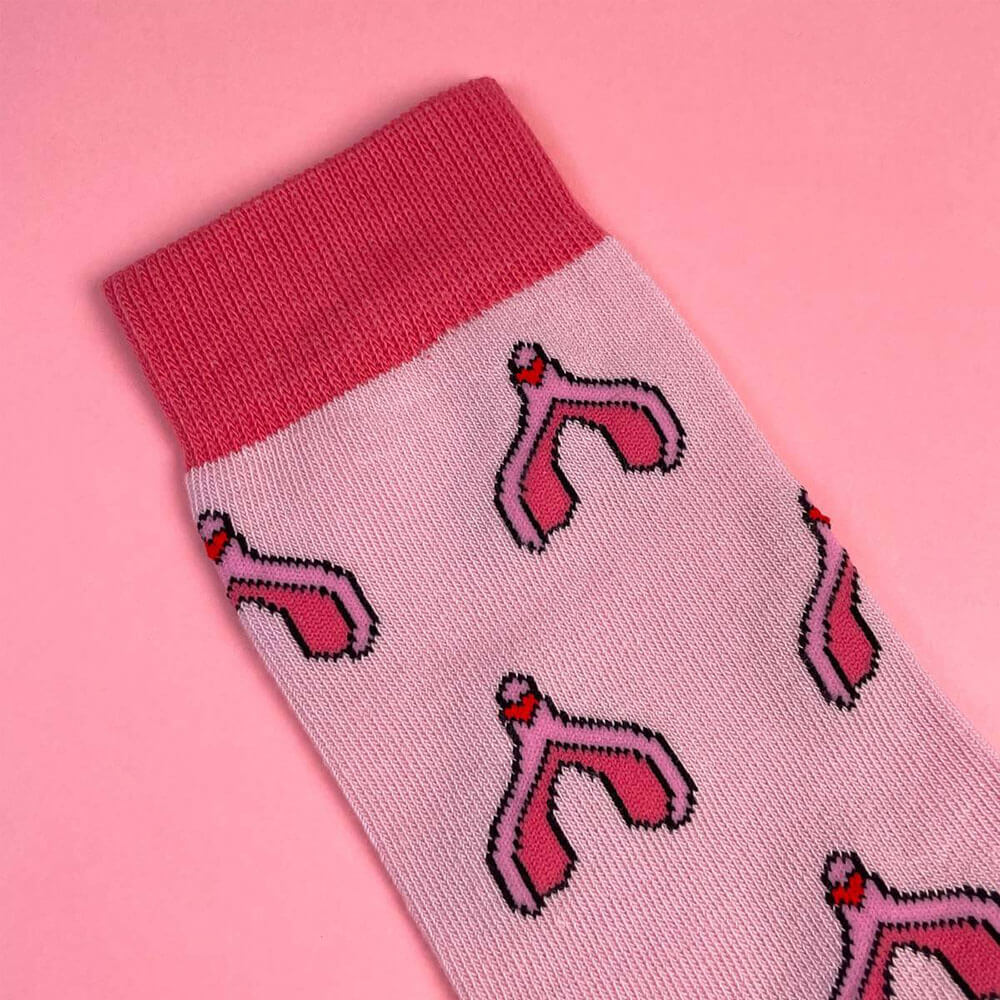 Close up of pink cotton socks with a clitoris print over a pink background Nudie Co