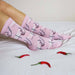 Pair of legs on a bed wearing pink cotton socks with hand on buttocks details Nudie Co