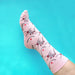 Foot wearing pink sock with boob and nipple print Nudie Co