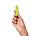 Hand holding a lime green bullet vibrator by Dame Nudie Co