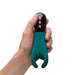 Hand holding a blue-coloured silicone penis vibrator by Fun Factory with black ABS handle and three buttons Nudie Co