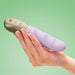 Woman's hand holding a lilac thrusting vibrator with golden handle and three buttons Nudie Co