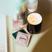 Vegan condoms next to candle and beauty self-care products Nudie Co