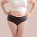 Front view of woman wearing white t-shirt and black shortie latex underwear Nudie Co
