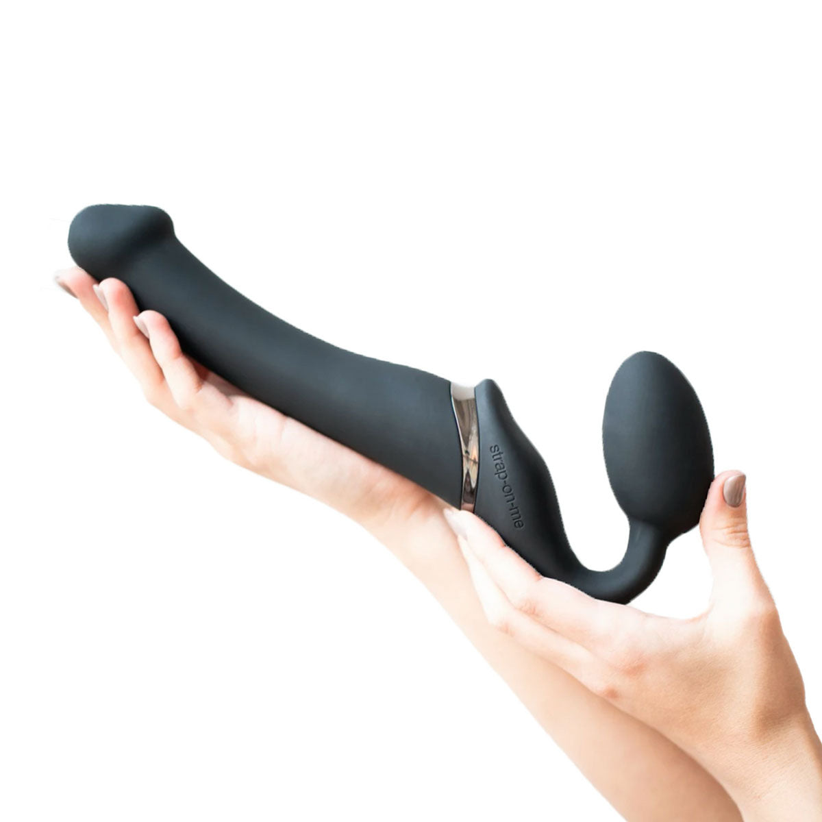 Hands holding a black silicone bendable strap-on with bulb for internal stimulation Nudie Co