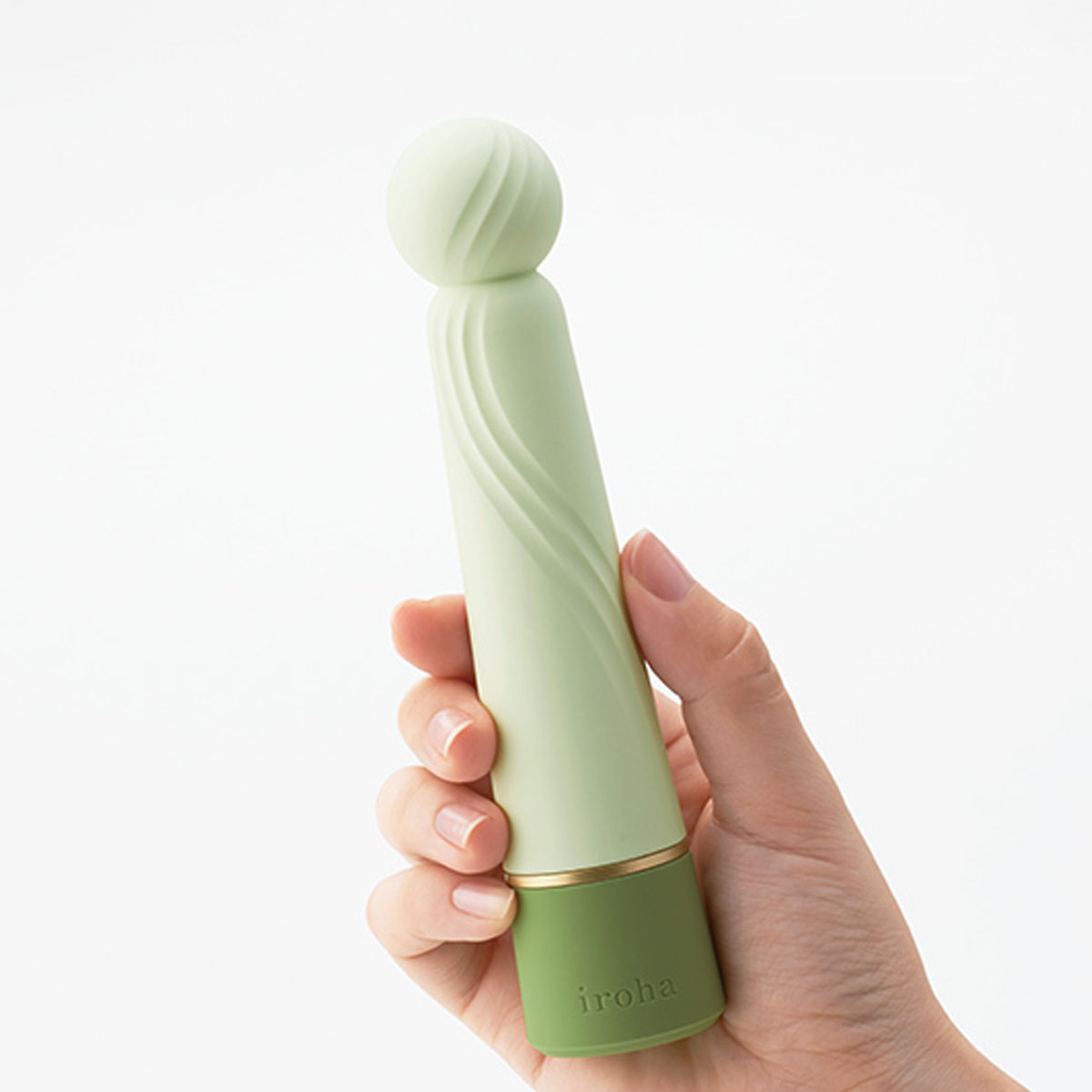 Hand holding a green silicone g-spot vibrator with squishy flexible ball at the top Nudie Co