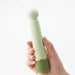 Hand holding a green silicone g-spot vibrator with squishy flexible ball at the top Nudie Co