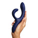 Hand holding a navy silicone vibrator with flexible tip for clitoris stimulation Nudie Co