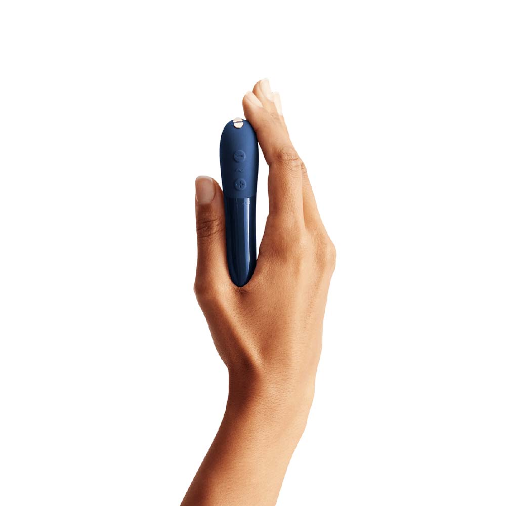 Hand holding a small navy bullet vibrator with ABS pointy tip and silicone handle Nudie Co