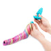 Person holding blue textured silicone butt plug in one hand and the detachable magnetic multicoloured unicorn tail in the other hand Nudie Co