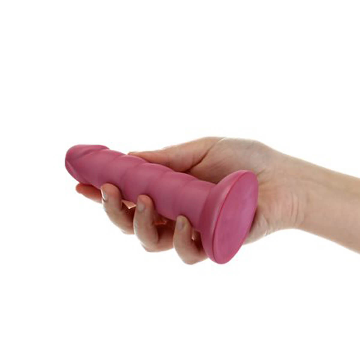 Hand holding a small pink dildo with ribbed texture and suction cup at the bottom Nudie Co