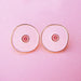 Front view of two pink boob-shaped pins Nudie Co