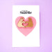 Packaging of enamel pin with two hands forming a love heart Nudie Co