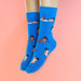 Woman's feet wearing blue socks printed with girls Nudie Co
